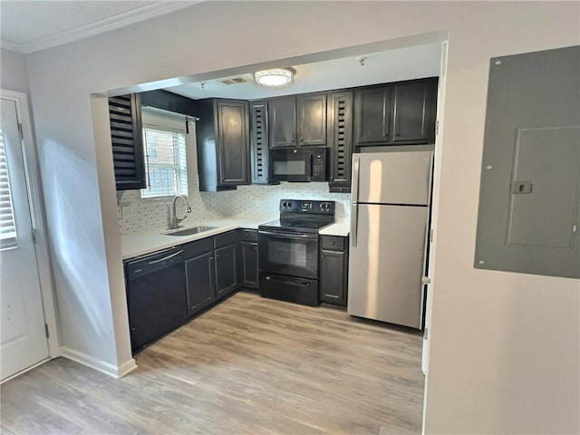 kitchen featuring sink, electric panel, black appliances, light hardwood / wood-style floors, and decorative backsplash