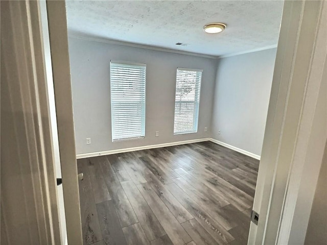 spare room with ornamental molding, dark hardwood / wood-style floors, and a textured ceiling