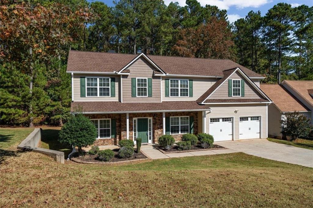 view of front facade featuring a front yard, a garage, and covered porch