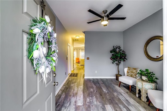 entryway featuring ceiling fan, visible vents, baseboards, and dark wood-type flooring