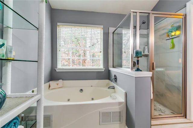 full bathroom with a tub with jets, plenty of natural light, and visible vents