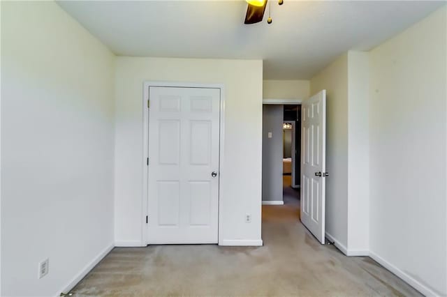 unfurnished bedroom with light carpet, ceiling fan, and baseboards