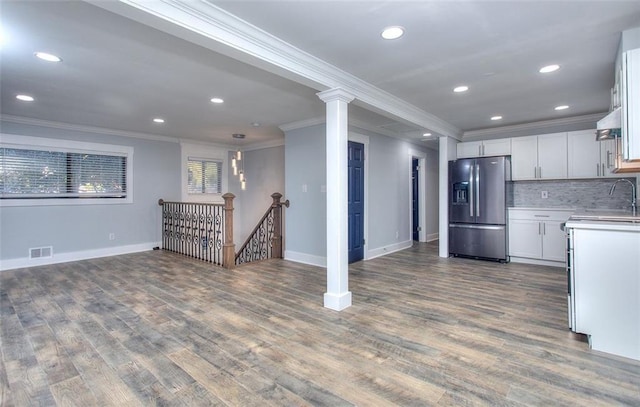 kitchen featuring white cabinetry, stainless steel refrigerator with ice dispenser, backsplash, crown molding, and hardwood / wood-style flooring