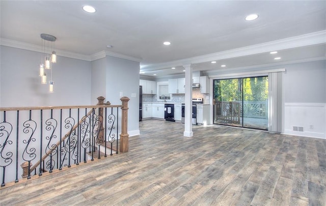 unfurnished living room with hardwood / wood-style floors and ornamental molding