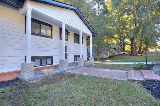 view of side of home with a porch and a yard