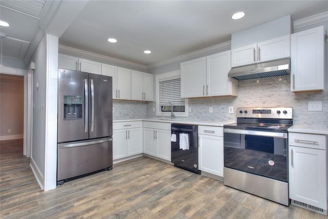 kitchen with backsplash, white cabinets, stainless steel appliances, and ornamental molding