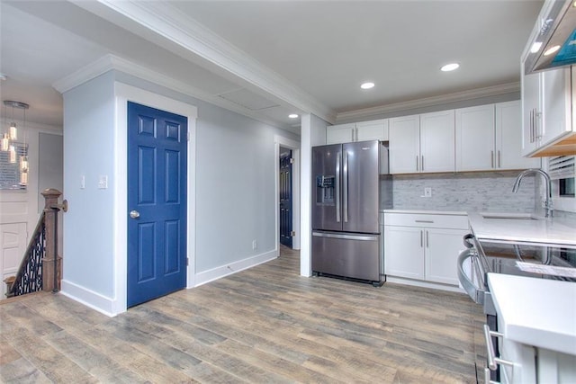 kitchen featuring white cabinets, decorative backsplash, sink, and stainless steel refrigerator with ice dispenser