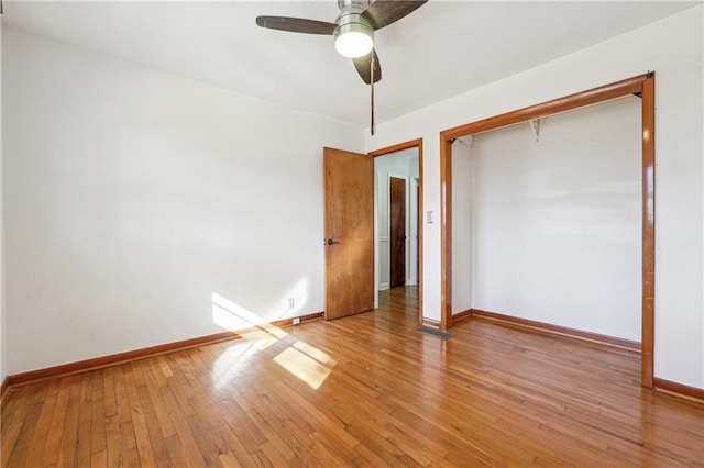 unfurnished bedroom featuring ceiling fan, a closet, and light wood-type flooring