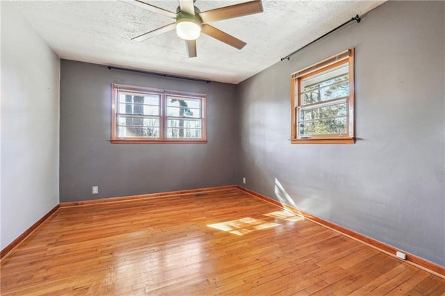 spare room featuring a textured ceiling, ceiling fan, and light hardwood / wood-style floors