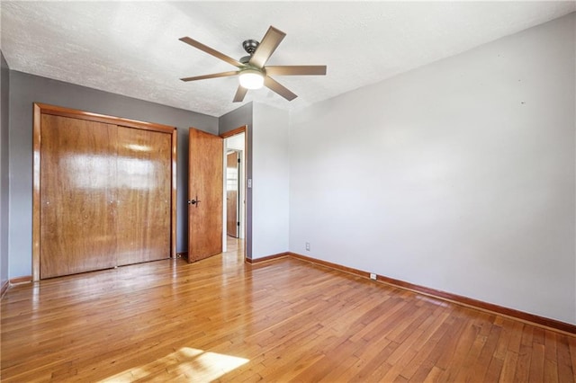 unfurnished bedroom with a textured ceiling, ceiling fan, a closet, and light hardwood / wood-style flooring