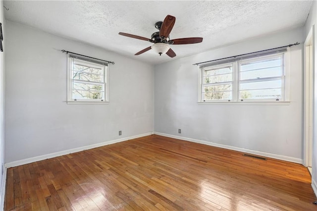 unfurnished room with ceiling fan, hardwood / wood-style floors, and a textured ceiling