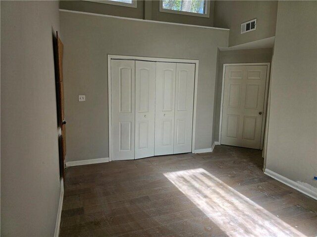 1920 Moores Mill Rd NW, Atlanta, GA 30318 - unfurnished bedroom with wood finished floors, baseboards, a closet, and visible vents