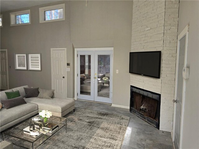 1920 Moores Mill Rd NW, Atlanta, GA 30318 - living room featuring a stone fireplace, baseboards, a high ceiling, and french doors