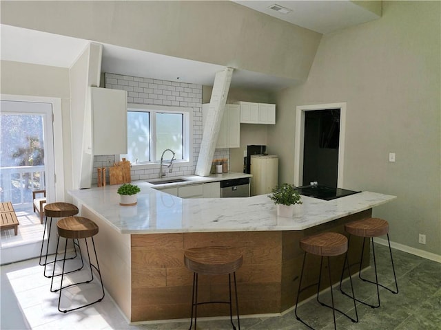 1920 Moores Mill Rd NW, Atlanta, GA 30318 - kitchen with decorative backsplash, white cabinets, a peninsula, a sink, and stainless steel dishwasher