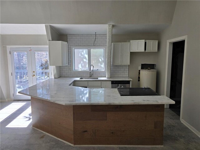 1920 Moores Mill Rd NW, Atlanta, GA 30318 - kitchen featuring white cabinetry, backsplash, a sink, light stone counters, and a peninsula