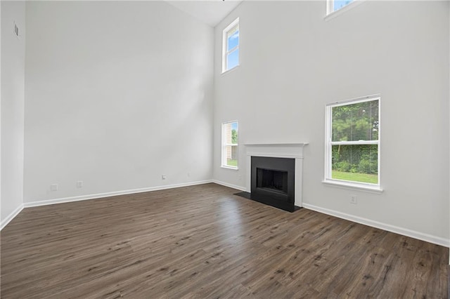 3405 Summer Brooke Way, Union City, GA 30291 - unfurnished living room featuring a towering ceiling, dark wood-style flooring, and a fireplace with flush hearth