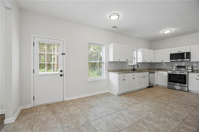3405 Summer Brooke Way, Union City, GA 30291 - kitchen with appliances with stainless steel finishes, plenty of natural light, backsplash, white cabinets, and a textured ceiling
