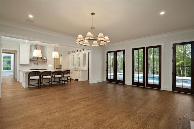 living area featuring a chandelier, crown molding, dark wood finished floors, recessed lighting, and baseboards