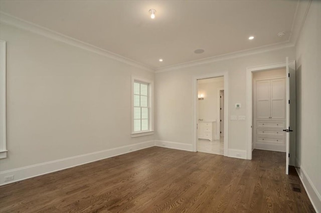 unfurnished bedroom featuring crown molding, dark wood-type flooring, baseboards, and recessed lighting