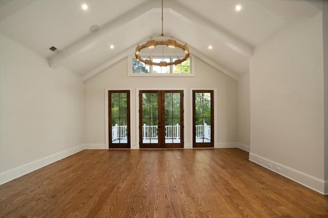 foyer with french doors, a chandelier, wood finished floors, baseboards, and high vaulted ceiling