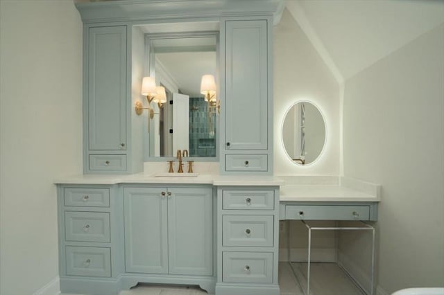 full bathroom featuring vanity, baseboards, and vaulted ceiling