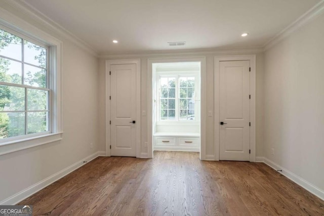 unfurnished bedroom featuring crown molding, wood finished floors, baseboards, and recessed lighting
