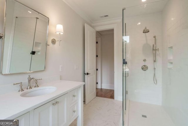 full bathroom featuring a stall shower, vanity, marble look tile flooring, and crown molding