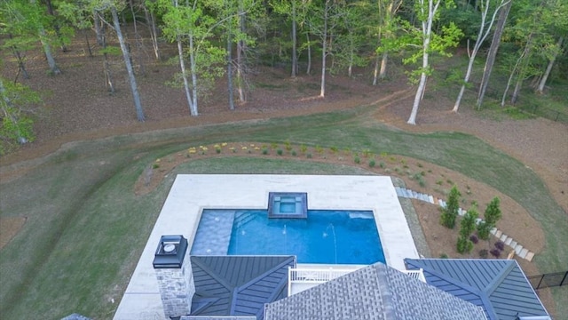 view of swimming pool featuring a pool with connected hot tub, a patio, and a yard