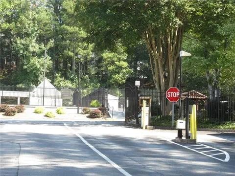 3828 Woodridge Way, Tucker, GA 30084 - view of asphalt street with a gate and traffic signs