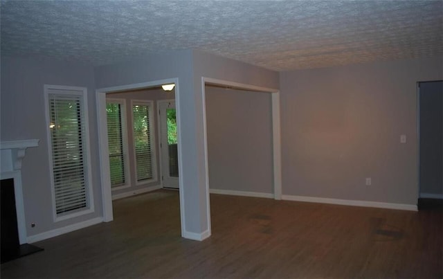 3828 Woodridge Way, Tucker, GA 30084 - unfurnished living room with wood finished floors, a textured ceiling, and a fireplace with raised hearth