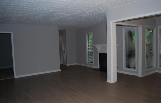 3828 Woodridge Way, Tucker, GA 30084 - unfurnished living room featuring wood finished floors, a fireplace with raised hearth, and a textured ceiling