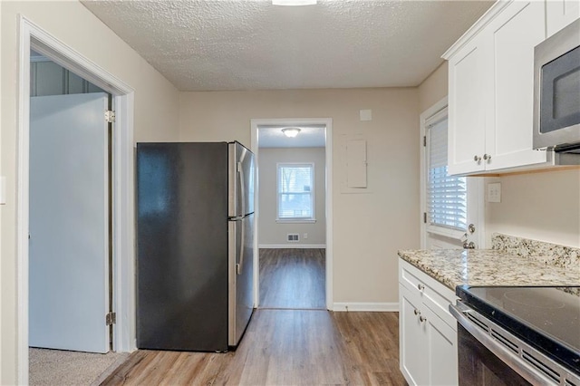 2504 Brentwood Rd, Decatur, GA 30032 - kitchen featuring a textured ceiling, light wood-type flooring, white cabinets, and stainless steel appliances