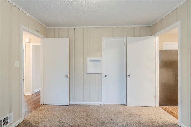2504 Brentwood Rd, Decatur, GA 30032 - unfurnished bedroom with a closet, a textured ceiling, visible vents, ornamental molding, and carpet floors