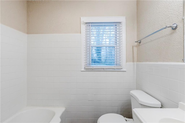 2504 Brentwood Rd, Decatur, GA 30032 - bathroom featuring tile walls, toilet, vanity, a textured wall, and wainscoting