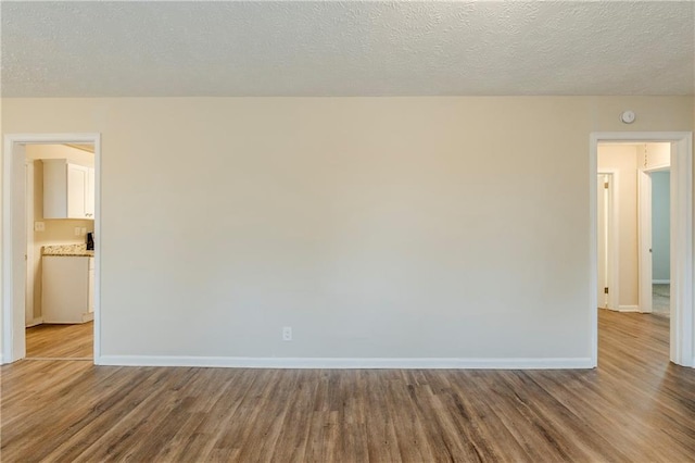 2504 Brentwood Rd, Decatur, GA 30032 - unfurnished room featuring baseboards, a textured ceiling, and wood finished floors