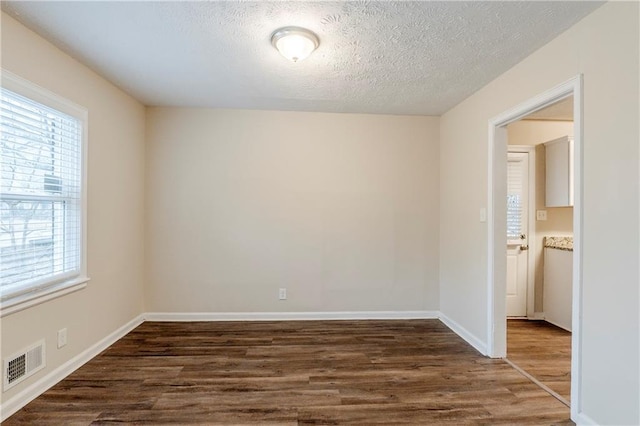 2504 Brentwood Rd, Decatur, GA 30032 - empty room featuring dark wood-type flooring, baseboards, a textured ceiling, and visible vents