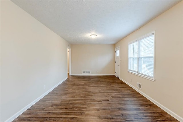 2504 Brentwood Rd, Decatur, GA 30032 - empty room featuring baseboards, visible vents, dark wood-style flooring, and a textured ceiling
