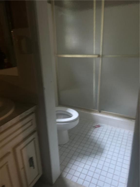 bathroom with vanity, tile patterned floors, toilet, and walk in shower