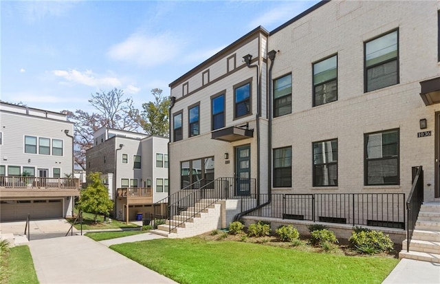 townhome / multi-family property featuring a garage and a front lawn