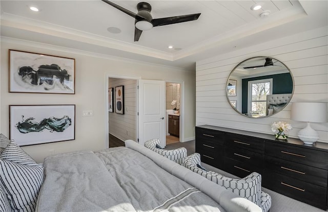 bedroom with ceiling fan, connected bathroom, ornamental molding, and a tray ceiling