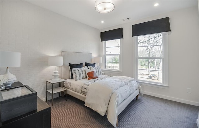 bedroom with dark colored carpet and brick wall