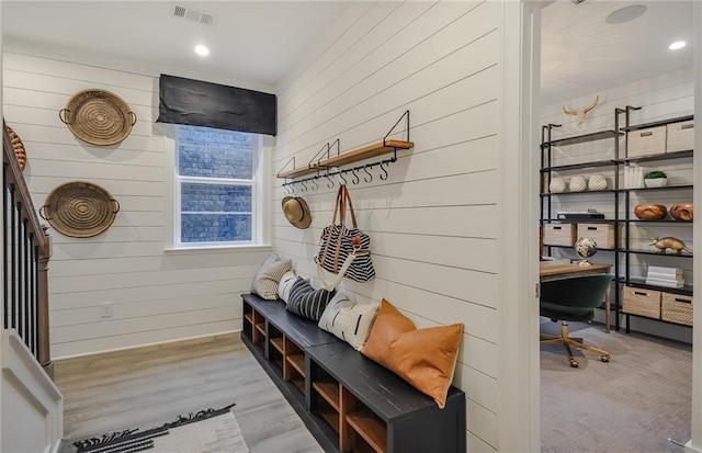 mudroom with wood walls and light wood-type flooring