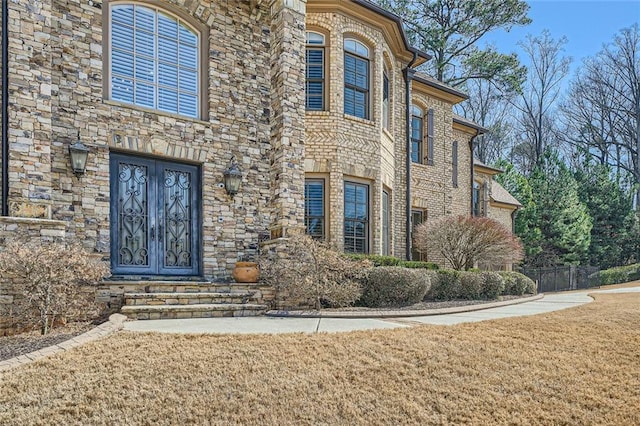 view of side of property featuring stone siding and a lawn