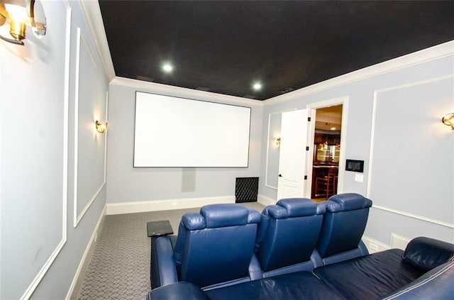 carpeted home theater featuring crown molding