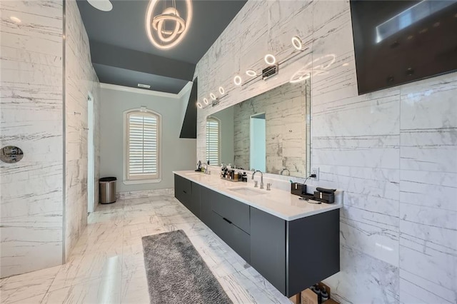 full bathroom featuring marble finish floor, a sink, tile walls, and double vanity