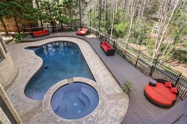 view of swimming pool with a fenced backyard, a pool with connected hot tub, outdoor lounge area, and a patio