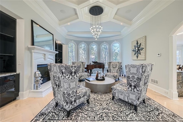 sitting room with ornamental molding, a glass covered fireplace, visible vents, and coffered ceiling