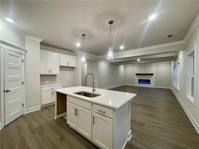 kitchen featuring a center island with sink, pendant lighting, white cabinets, and sink