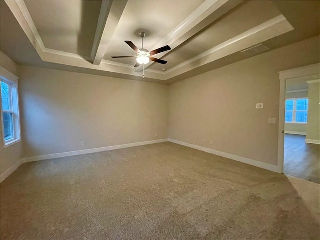 carpeted empty room featuring a raised ceiling, ceiling fan, and crown molding