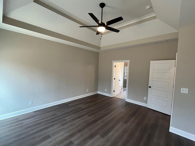 unfurnished room with dark wood-type flooring, ceiling fan, and a tray ceiling